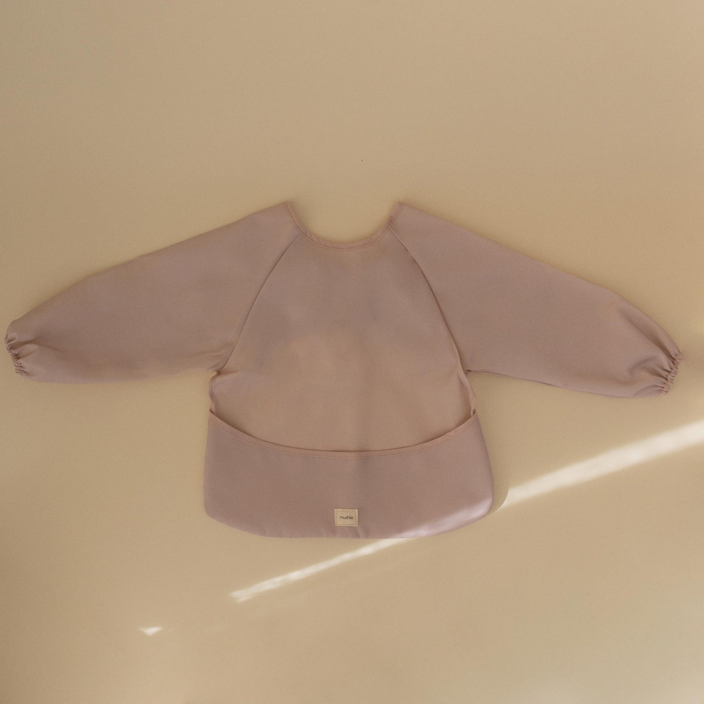 mushie Long Sleeve Baby Bib | Mess Free & Waterproof Fabric for Toddlers | Adjustable Fit for Ages 6-24 Months (Blush)