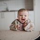 mushie Long Sleeve Baby Bib | Mess Free & Waterproof Fabric for Toddlers | Adjustable Fit for Ages 6-24 Months (Pastel Blooms)