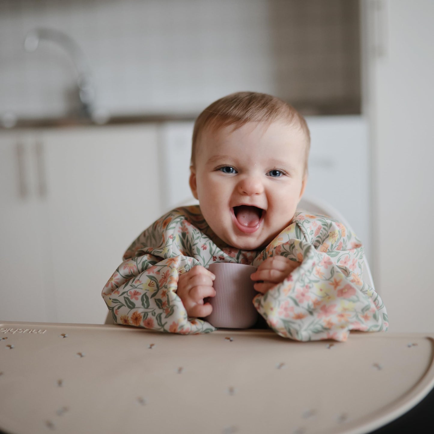 mushie Long Sleeve Baby Bib | Mess Free & Waterproof Fabric for Toddlers | Adjustable Fit for Ages 6-24 Months (Pastel Blooms)