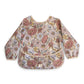 Mushie Long Sleeve Baby Bib | Mess Free & Waterproof Fabric For Toddlers | Adjustable Fit For Ages 6-24 Months (Retro Flowers)