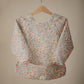 mushie Long Sleeve Baby Bib | Mess Free & Waterproof Fabric for Toddlers | Adjustable Fit for Ages 6-24 Months (Pastel Blooms)