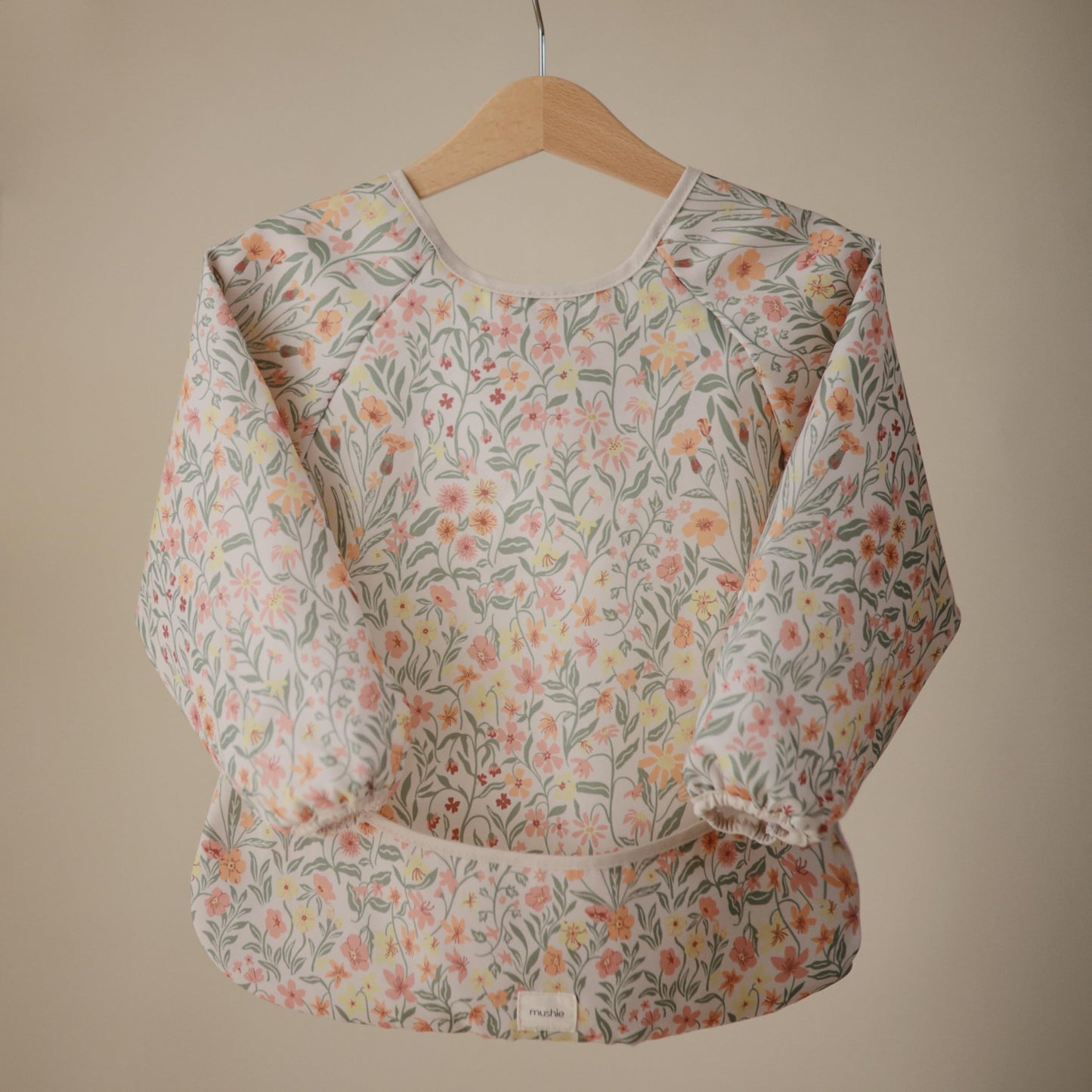 mushie Long Sleeve Baby Bib | Mess Free & Waterproof Fabric for Toddlers | Adjustable Fit for Ages 6-24 Months (Pastel Blooms)