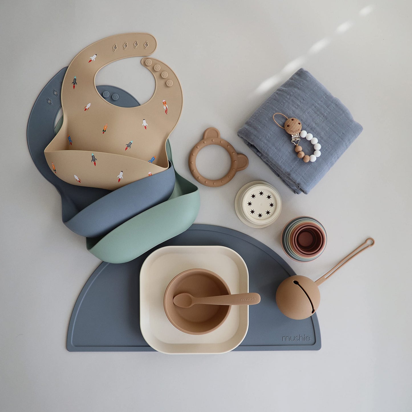 Mushie Silicone Baby Bib | Adjustable Fit Waterproof Bibs (Rocket Ship)